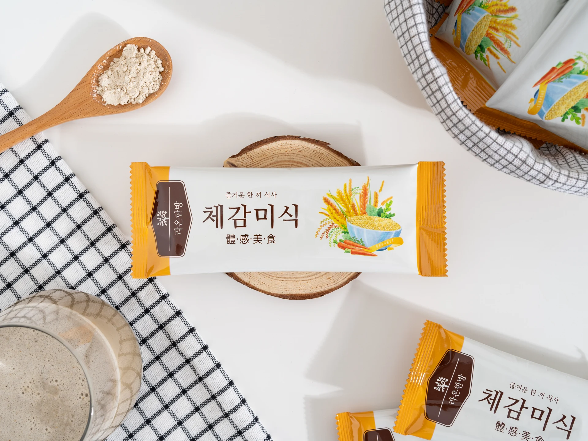 음료와 분말 스푼, 개별 포장을 함께 놓은 체감미식 식사 장면